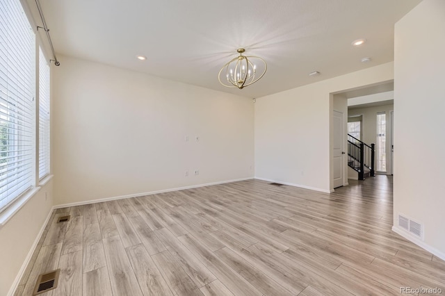 spare room featuring visible vents, a notable chandelier, recessed lighting, light wood-style floors, and baseboards