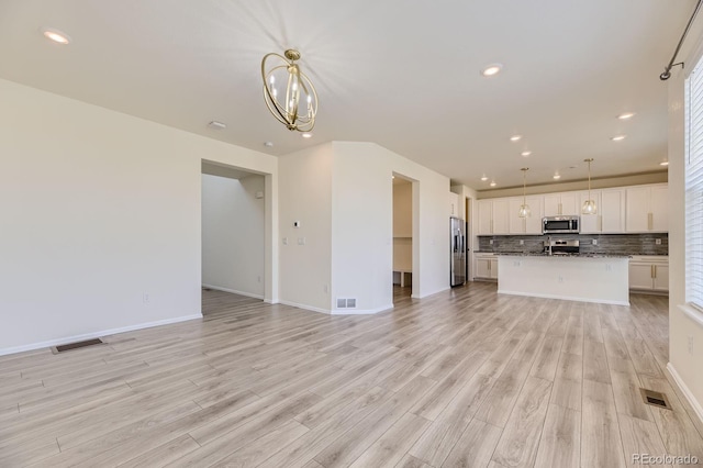 unfurnished living room featuring recessed lighting, visible vents, and light wood finished floors