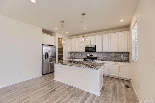 kitchen with tasteful backsplash, visible vents, appliances with stainless steel finishes, and a sink