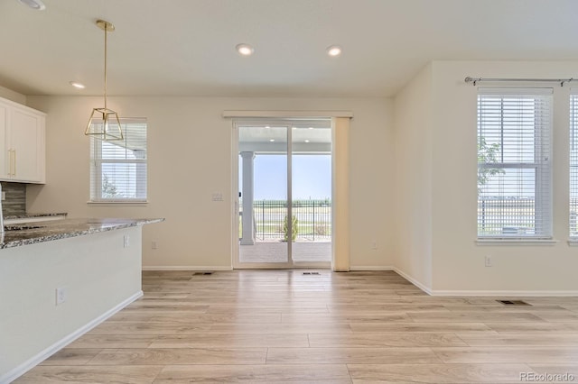 unfurnished dining area featuring visible vents, recessed lighting, light wood-type flooring, and baseboards