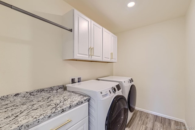 washroom with light wood-type flooring, recessed lighting, cabinet space, separate washer and dryer, and baseboards