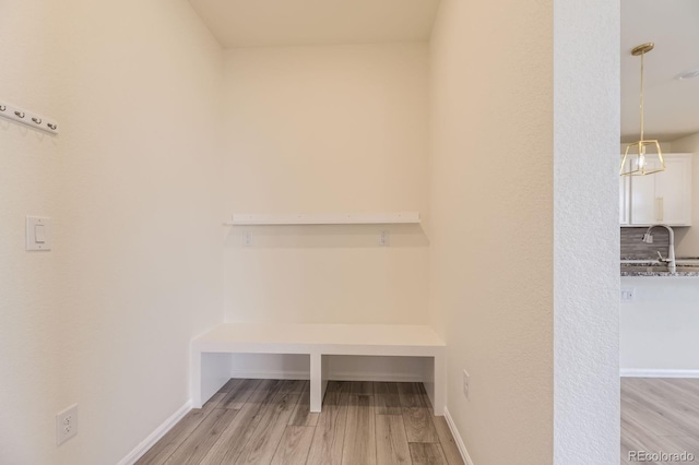 interior space featuring a sink, light wood-type flooring, and baseboards