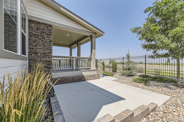 view of patio / terrace featuring fence and covered porch