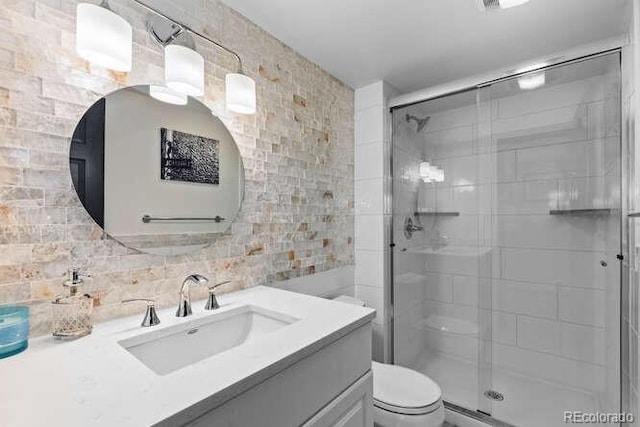 5955 Blue Sage Way, Littleton, CO 80123 - bathroom with tile walls, vanity, a stall shower, and tasteful backsplash