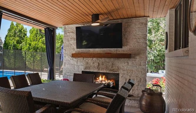 5955 Blue Sage Way, Littleton, CO 80123 - view of patio / terrace with an outdoor stone fireplace, a ceiling fan, and outdoor dining space