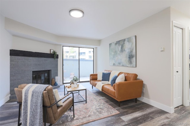 living room featuring a fireplace and dark wood-type flooring