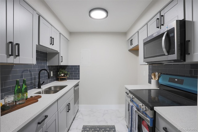 kitchen featuring tasteful backsplash, light stone counters, light tile floors, sink, and appliances with stainless steel finishes