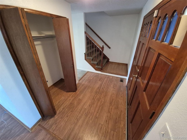 3136 S Cathay Cir, Aurora, CO 80013 - foyer entrance featuring wood finished floors, stairway, baseboards, and a textured ceiling