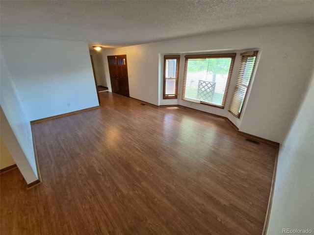 3136 S Cathay Cir, Aurora, CO 80013 - spare room with wood finished floors, baseboards, and a textured ceiling