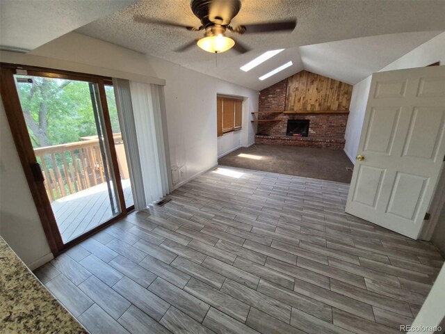 3136 S Cathay Cir, Aurora, CO 80013 - unfurnished living room featuring a ceiling fan, vaulted ceiling, healthy amount of natural light, a fireplace, and baseboards