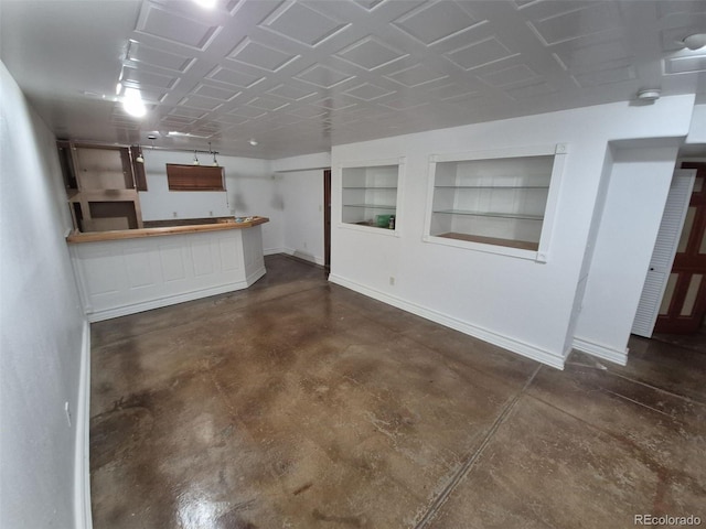 3136 S Cathay Cir, Aurora, CO 80013 - unfurnished living room with finished concrete floors, baseboards, built in shelves, and bar area