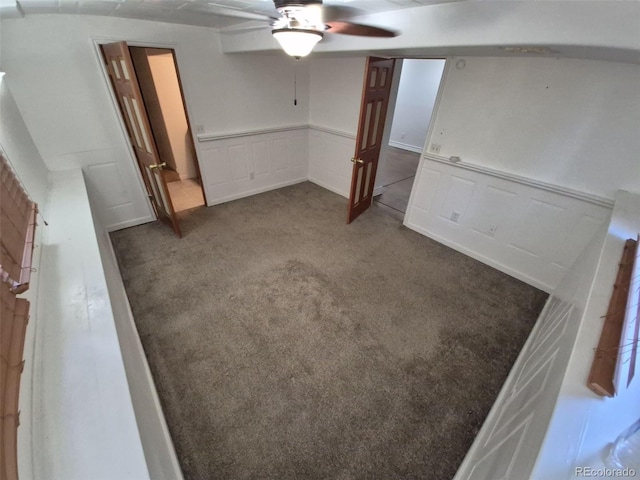 3136 S Cathay Cir, Aurora, CO 80013 - unfurnished living room featuring carpet flooring, ceiling fan, wainscoting, and a decorative wall