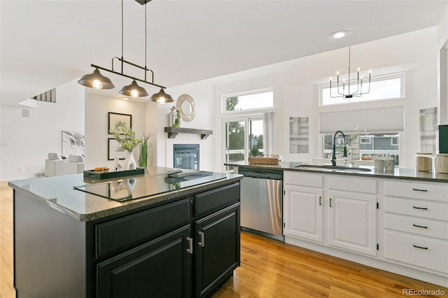 kitchen with sink, dishwasher, white cabinetry, a center island, and black electric stovetop