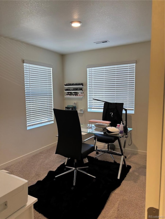 carpeted home office featuring a textured ceiling