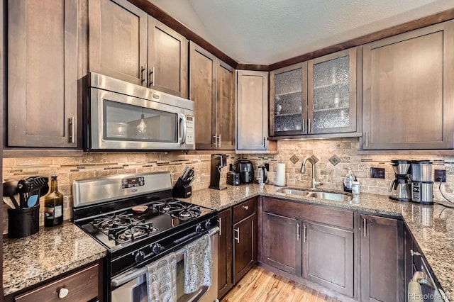 2841 N Columbine St, Denver, CO 80205 - kitchen featuring stainless steel appliances, decorative backsplash, light stone countertops, a textured ceiling, and dark brown cabinets