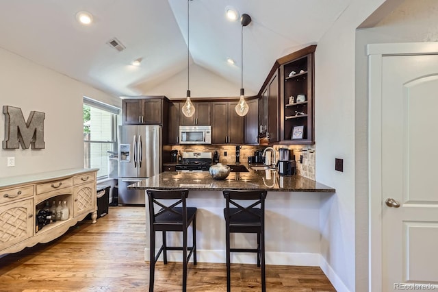 2841 N Columbine St, Denver, CO 80205 - kitchen featuring stainless steel appliances, dark brown cabinets, dark stone counters, backsplash, and lofted ceiling