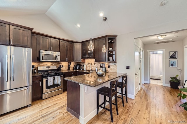 2841 N Columbine St, Denver, CO 80205 - kitchen with stainless steel appliances, open shelves, dark brown cabinetry, dark stone counters, and a kitchen breakfast bar