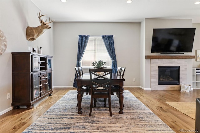 dining room with a fireplace and light hardwood / wood-style flooring