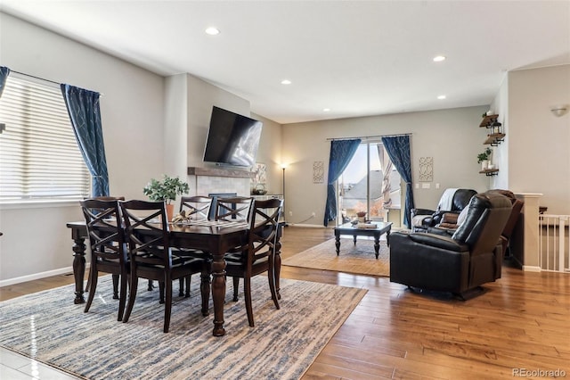 dining room with hardwood / wood-style flooring and a fireplace