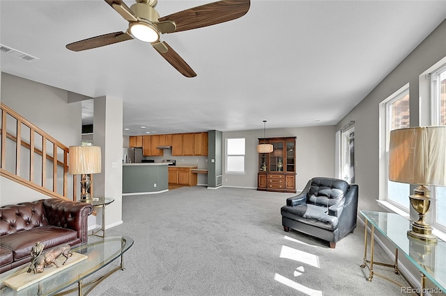 5564 Kalispell St, Denver, CO 80239 - living room with light carpet, ceiling fan, and stairway
