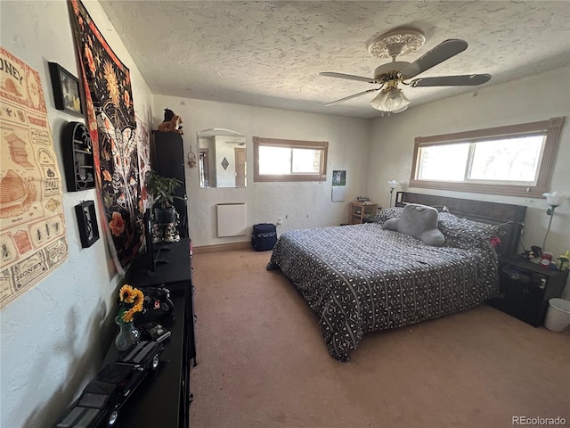 300 3rd St, Saguache, CO 81149 - carpeted bedroom with arched walkways, a ceiling fan, and a textured ceiling