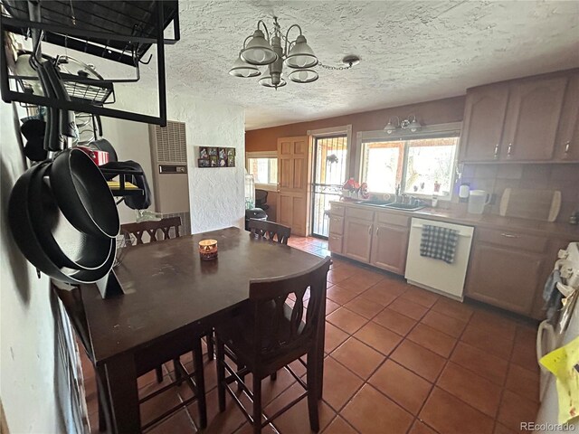 300 3rd St, Saguache, CO 81149 - kitchen featuring a textured ceiling, dishwasher, light tile patterned floors, a sink, and a notable chandelier