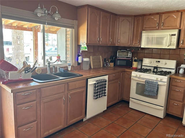 300 3rd St, Saguache, CO 81149 - kitchen with a sink, white appliances, a textured ceiling, backsplash, and dark tile patterned flooring
