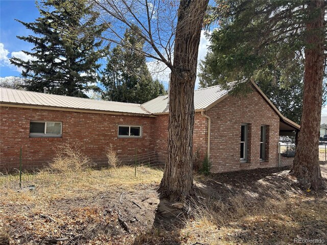 300 3rd St, Saguache, CO 81149 - view of side of home with brick siding and metal roof