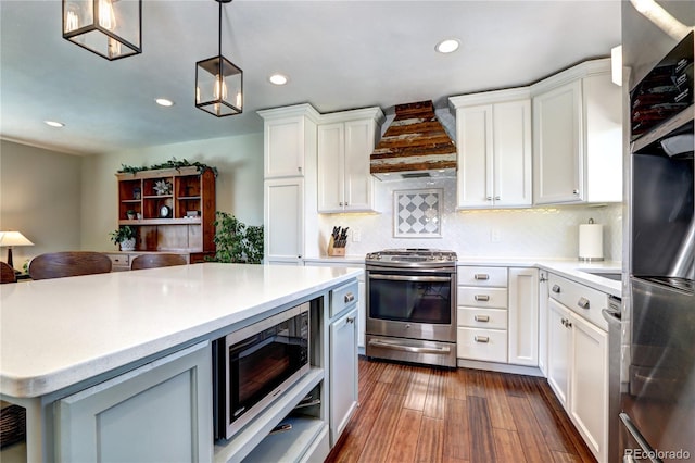 13915 W 73rd Ave, Arvada, CO 80005 - kitchen with stainless steel appliances, custom exhaust hood, light countertops, recessed lighting, and white cabinets