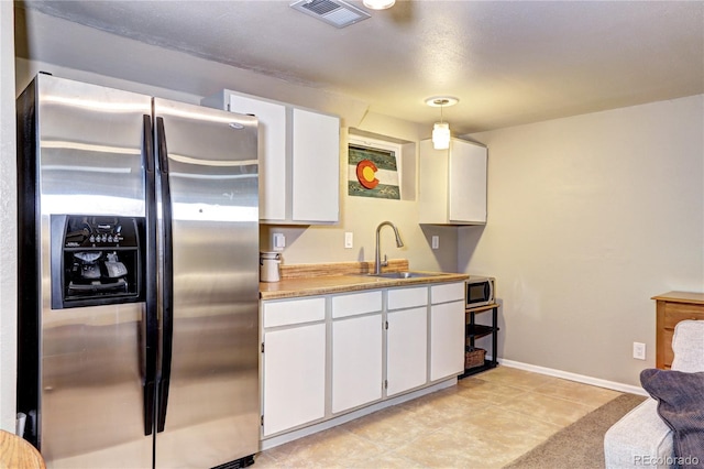 13915 W 73rd Ave, Arvada, CO 80005 - kitchen with appliances with stainless steel finishes, white cabinetry, light countertops, decorative light fixtures, and light tile patterned floors