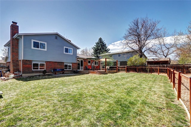 13915 W 73rd Ave, Arvada, CO 80005 - back of house featuring a chimney, a fenced backyard, and brick siding