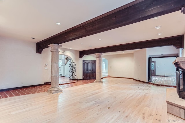 unfurnished living room with baseboards, beam ceiling, recessed lighting, light wood-style floors, and ornate columns