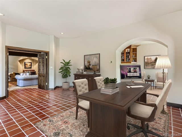 office space featuring tile patterned floors, recessed lighting, baseboards, and arched walkways