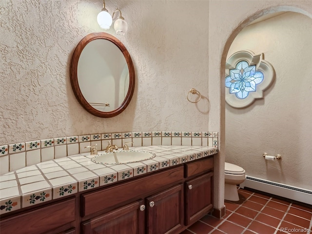 bathroom with tile patterned floors, baseboard heating, toilet, and a textured wall