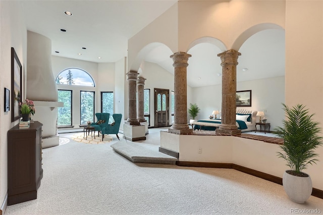 interior space featuring recessed lighting, carpet floors, a towering ceiling, and ornate columns