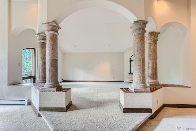 living area featuring a baseboard heating unit, decorative columns, and carpet