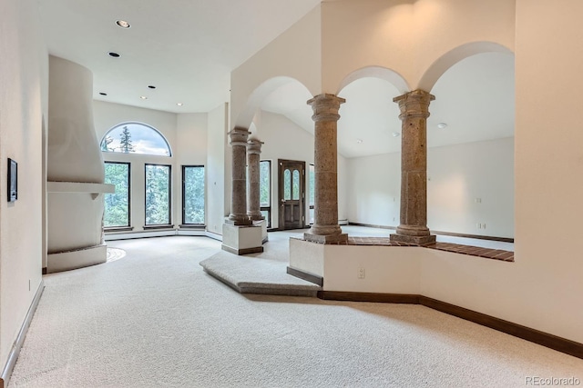 interior space with recessed lighting, carpet floors, a high ceiling, baseboards, and ornate columns