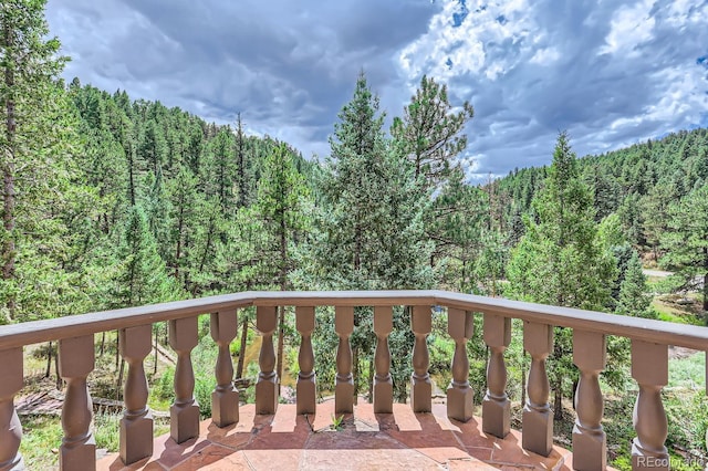 balcony featuring a wooded view