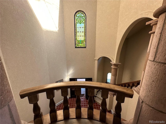 stairs with arched walkways and a textured wall