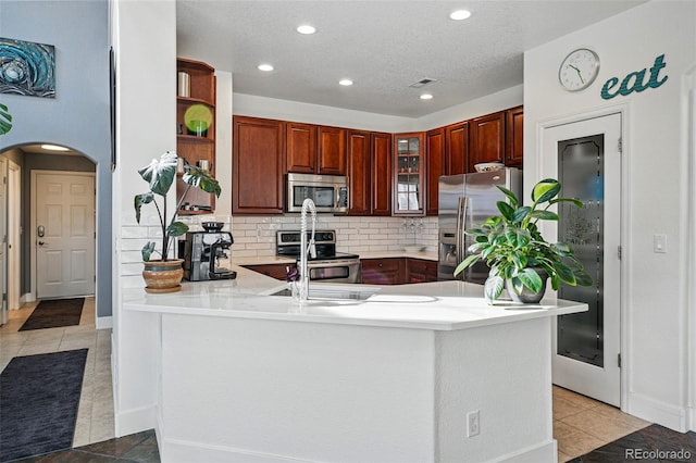 11307 Navajo Cir Unit A, Westminster, CO 80234 - kitchen featuring appliances with stainless steel finishes, a peninsula, open shelves, arched walkways, and recessed lighting