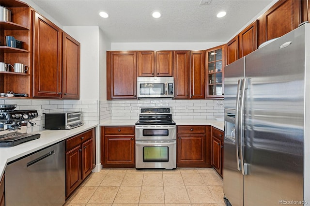 11307 Navajo Cir Unit A, Westminster, CO 80234 - kitchen with appliances with stainless steel finishes, light countertops, open shelves, recessed lighting, and a textured ceiling