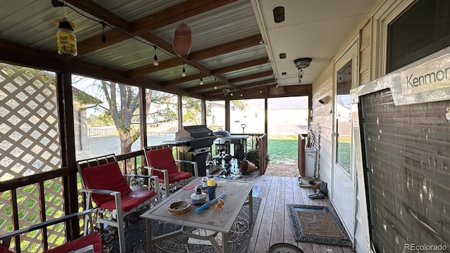 sunroom / solarium with lofted ceiling with beams and a healthy amount of sunlight