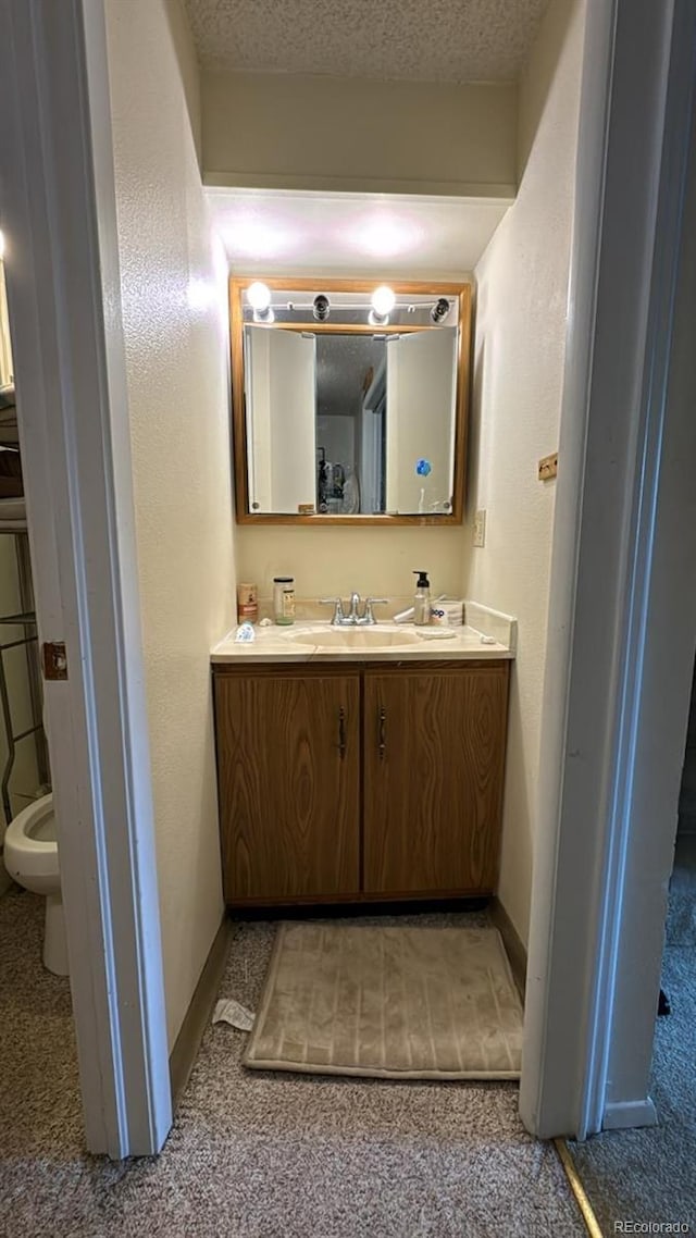 bathroom with vanity, a textured ceiling, and toilet