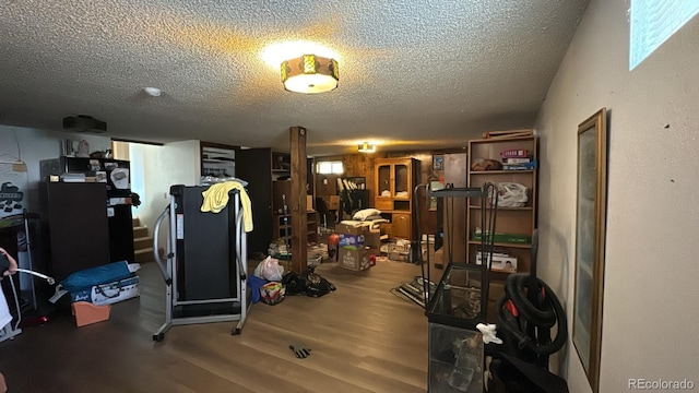 workout room with hardwood / wood-style floors and a textured ceiling