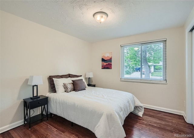 bedroom featuring dark hardwood / wood-style floors and a textured ceiling