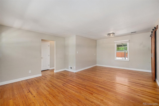 1920 Elmira St, Aurora, CO 80010 - spare room featuring light wood finished floors and a barn door