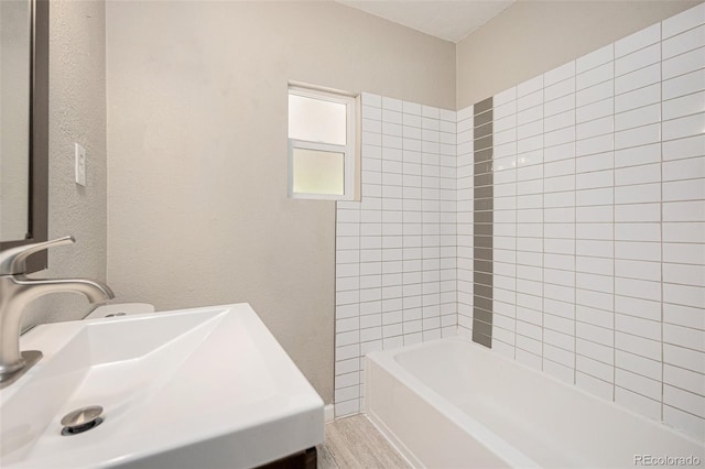 1920 Elmira St, Aurora, CO 80010 - full bath with wood finished floors, shower / bathtub combination, and a textured wall