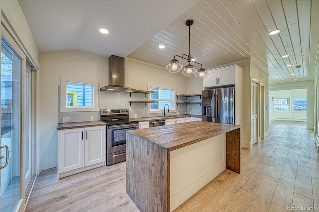 kitchen featuring wood counters, appliances with stainless steel finishes, wood ceiling, wall chimney range hood, and white cabinets