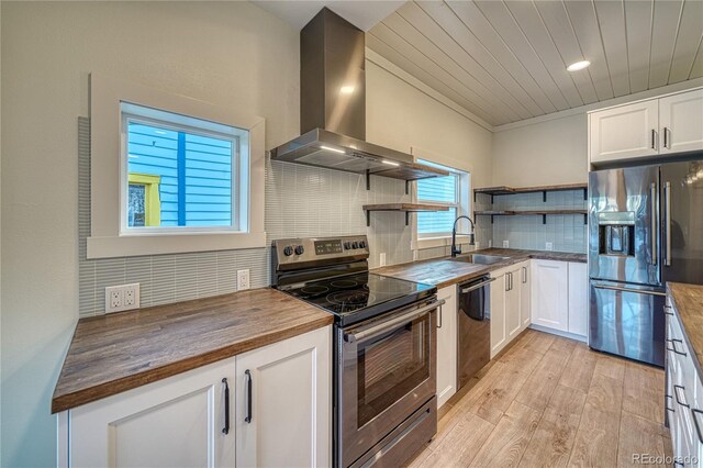 kitchen featuring exhaust hood, white cabinets, sink, butcher block countertops, and stainless steel appliances