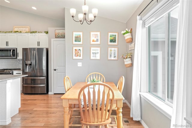 577 Tristan Pl, Berthoud, CO 80513 - dining area with vaulted ceiling, light wood finished floors, a chandelier, recessed lighting, and baseboards